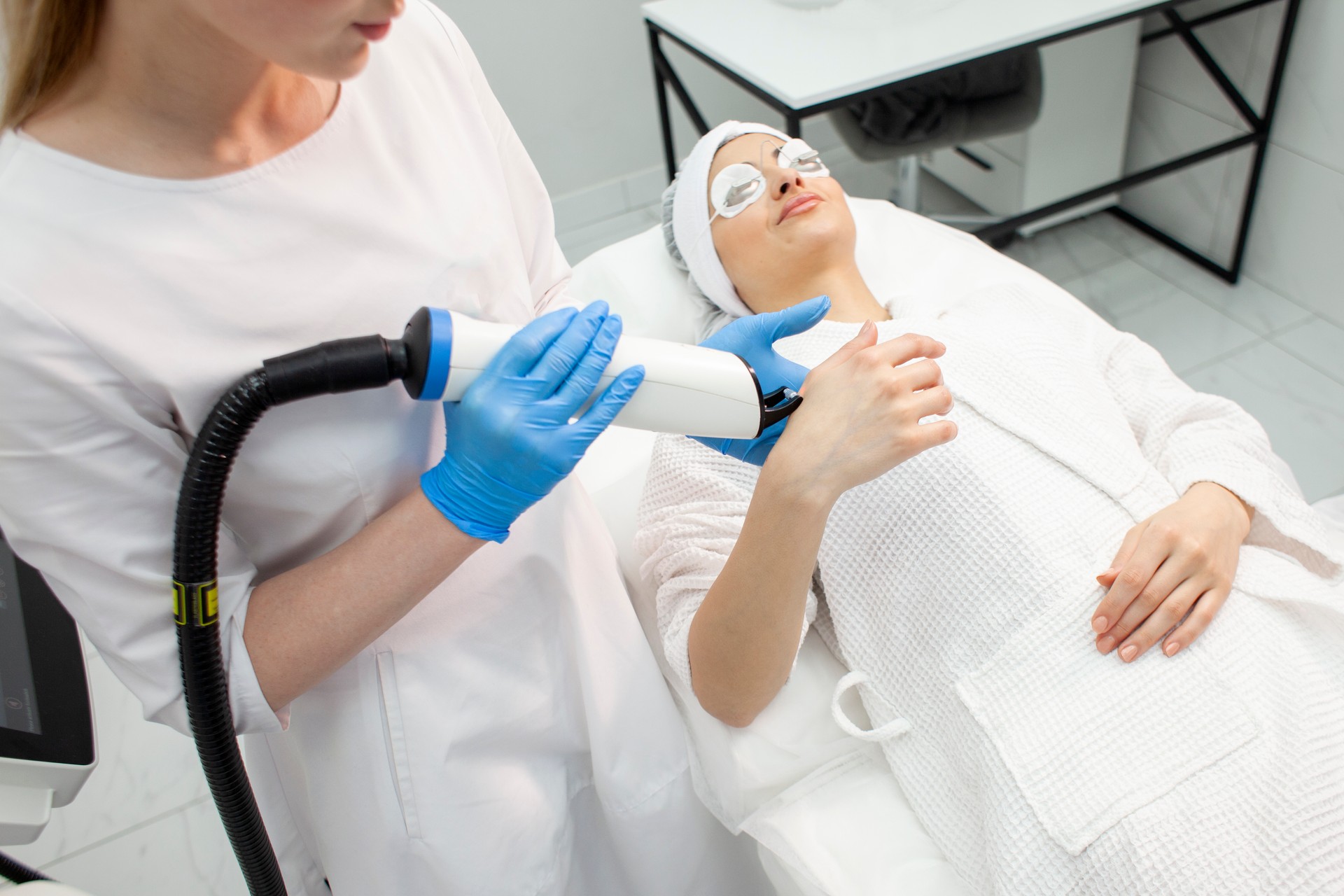 doctor cosmetologist holds a modern laser in his hands and presses the screen in a cosmetology clinic